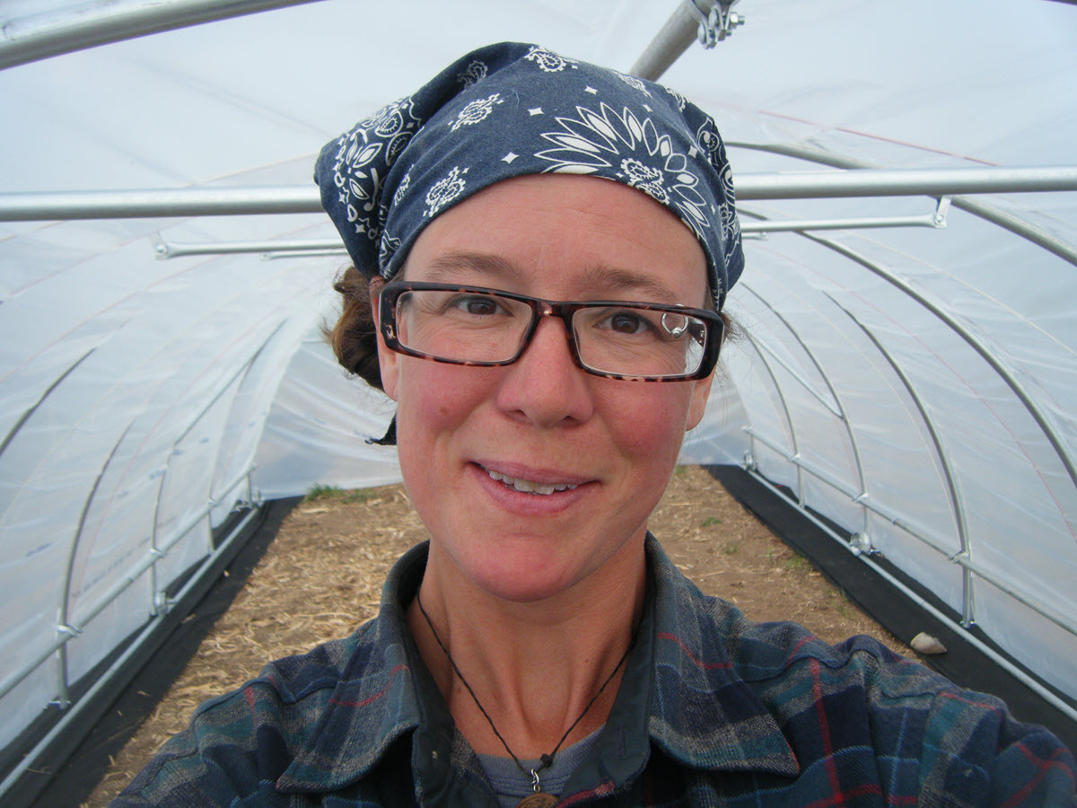 Picture of Jenn, smiling, in hoop house